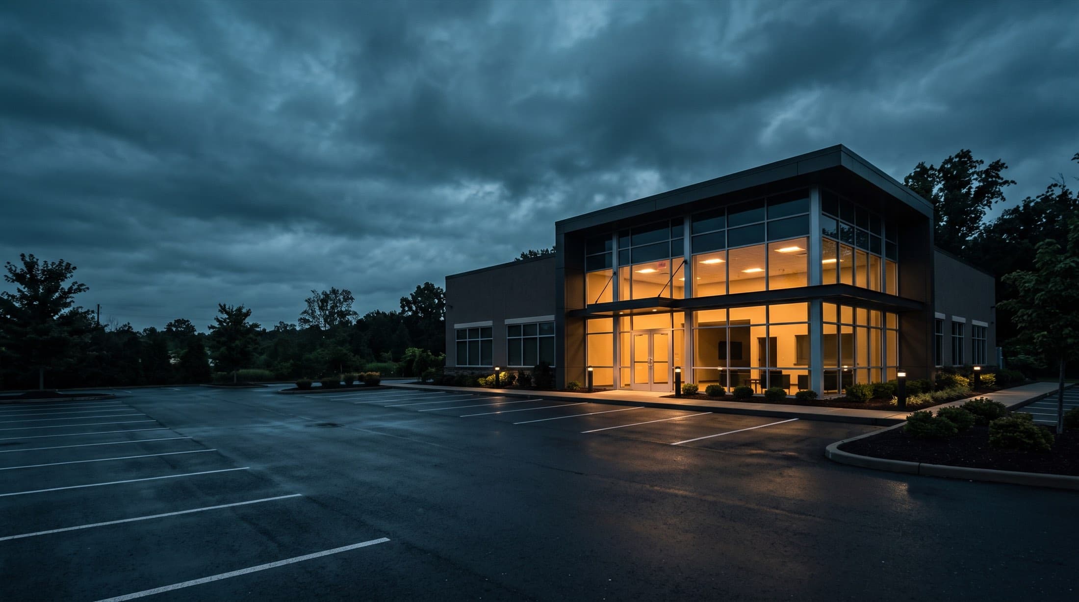 A pristine single-tenant net-lease commercial building glowing at dusk over an empty parking lot — a beautiful surface that can hide a manufactured lease