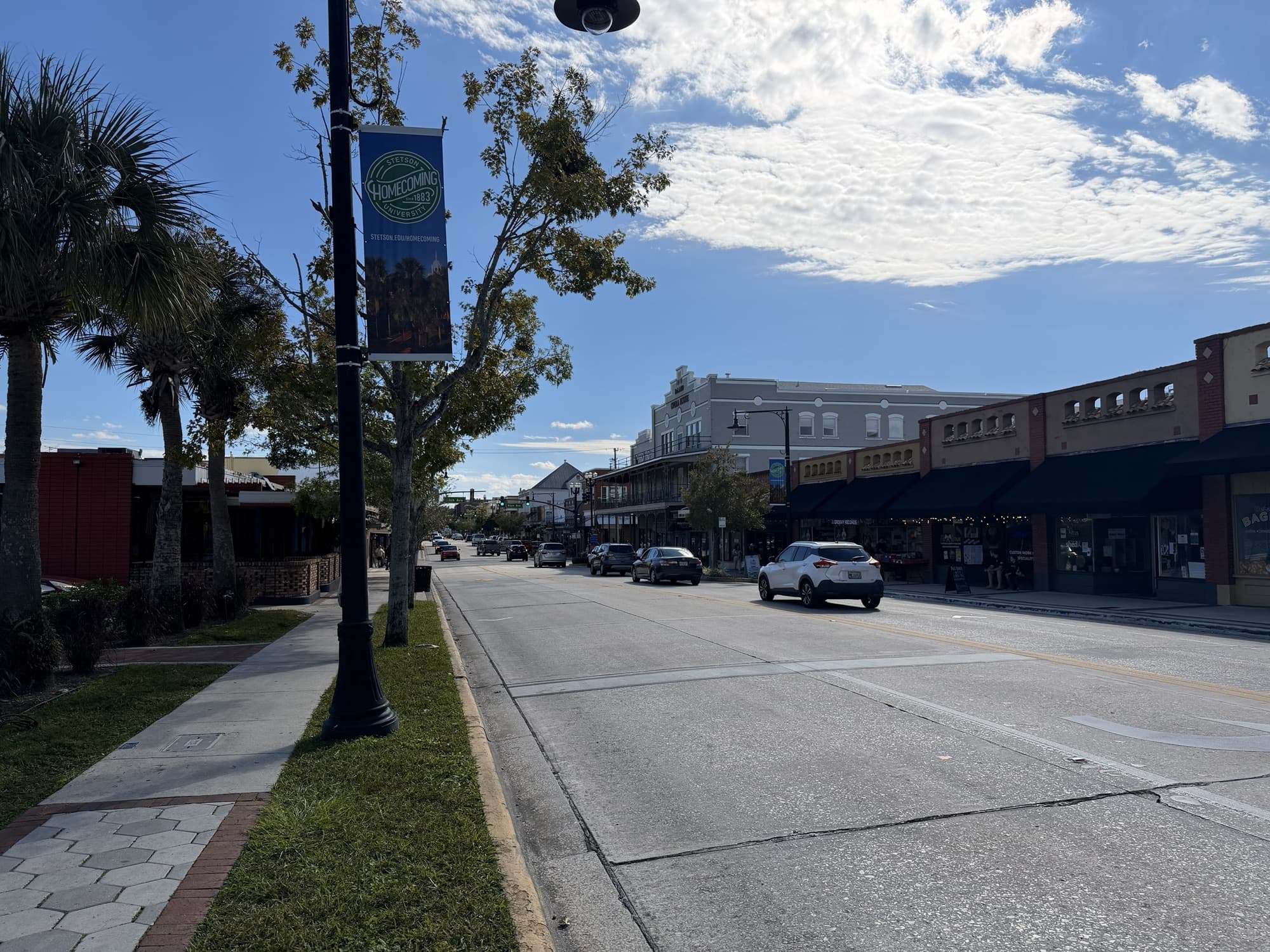 Woodland Boulevard in historic downtown DeLand, Florida, with storefronts and a Stetson University banner