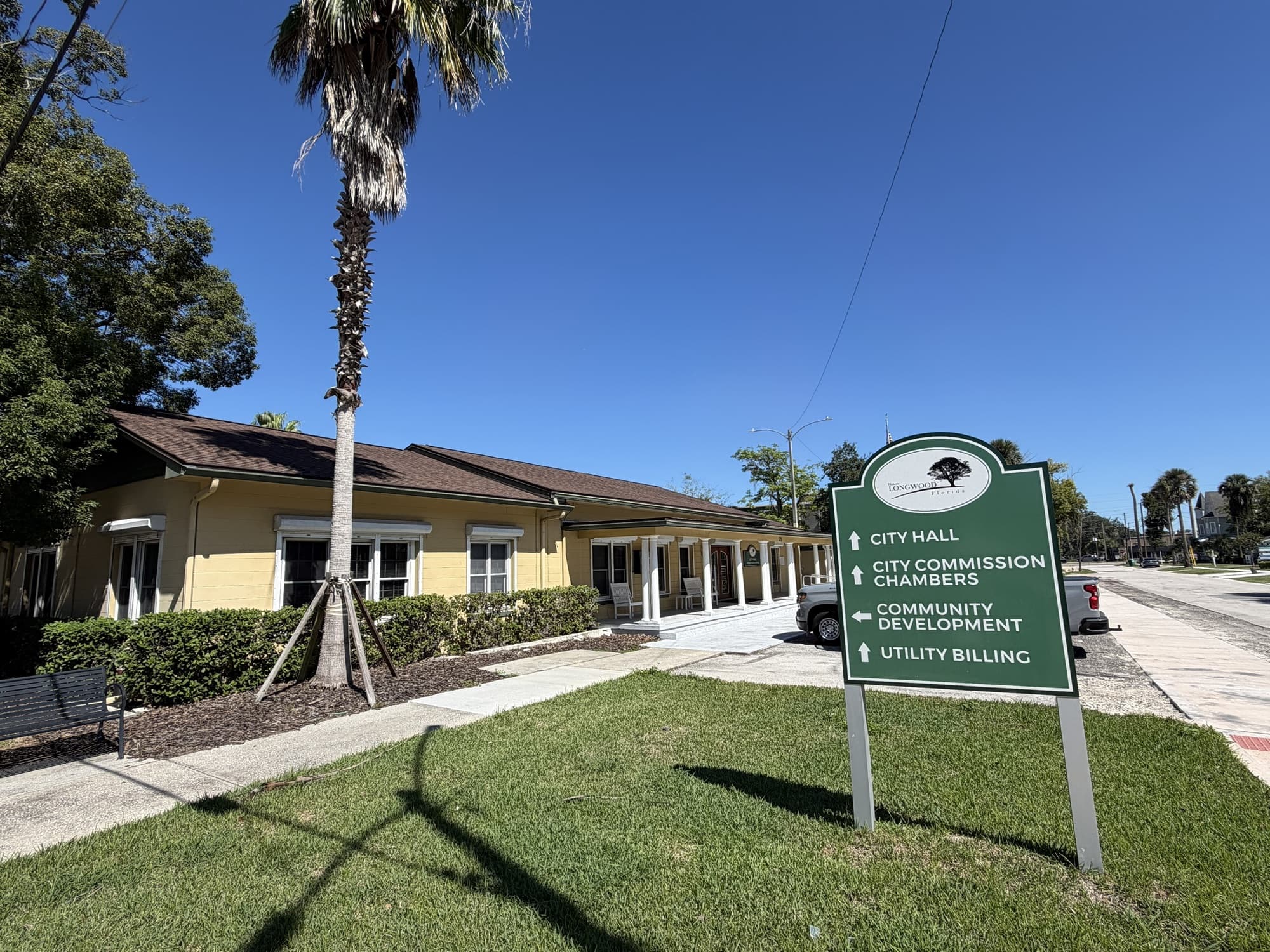 Longwood City Hall, a yellow historic building with a green City Hall sign, in Longwood, Florida